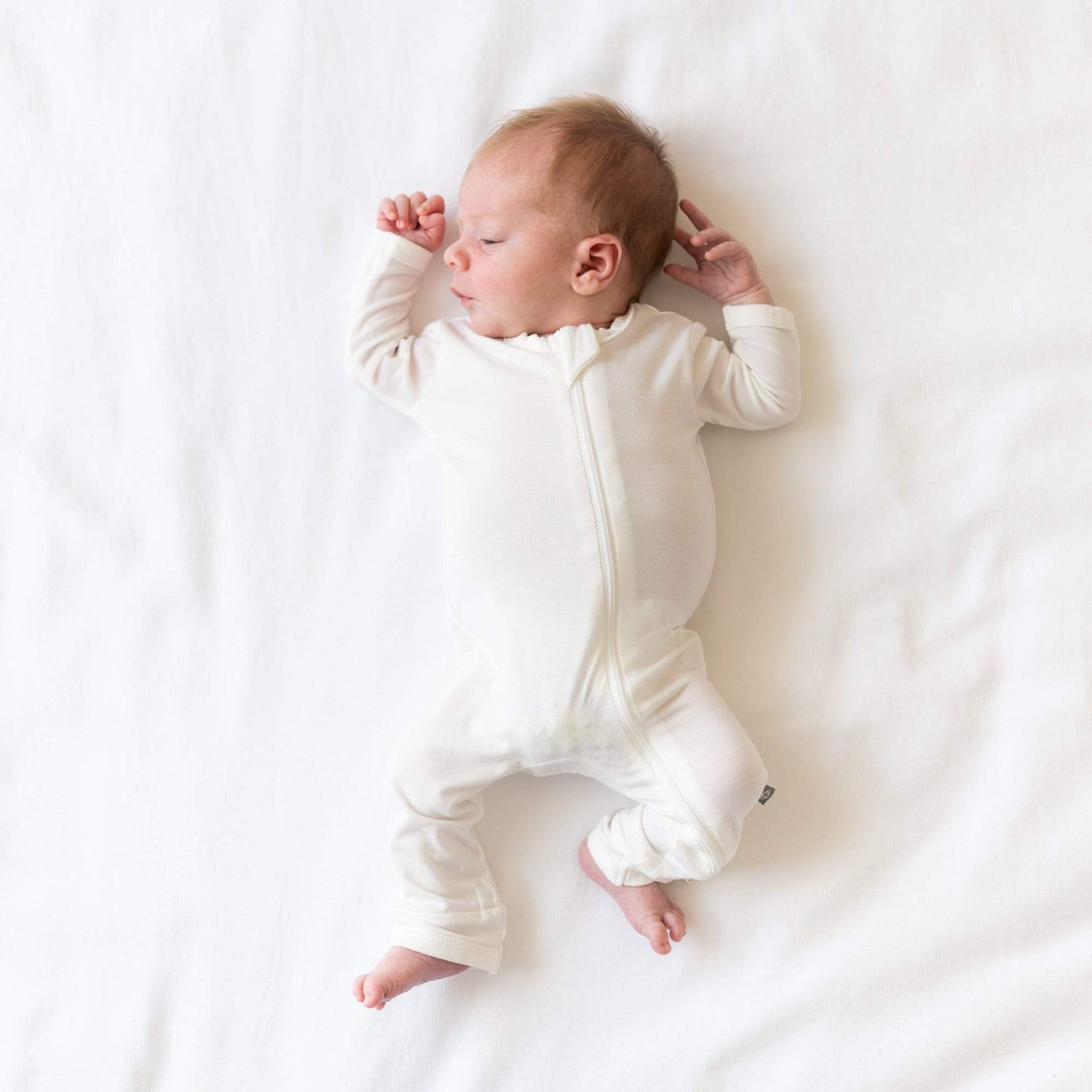 Infant wearing Kyte Baby Zippered Romper in Cloud