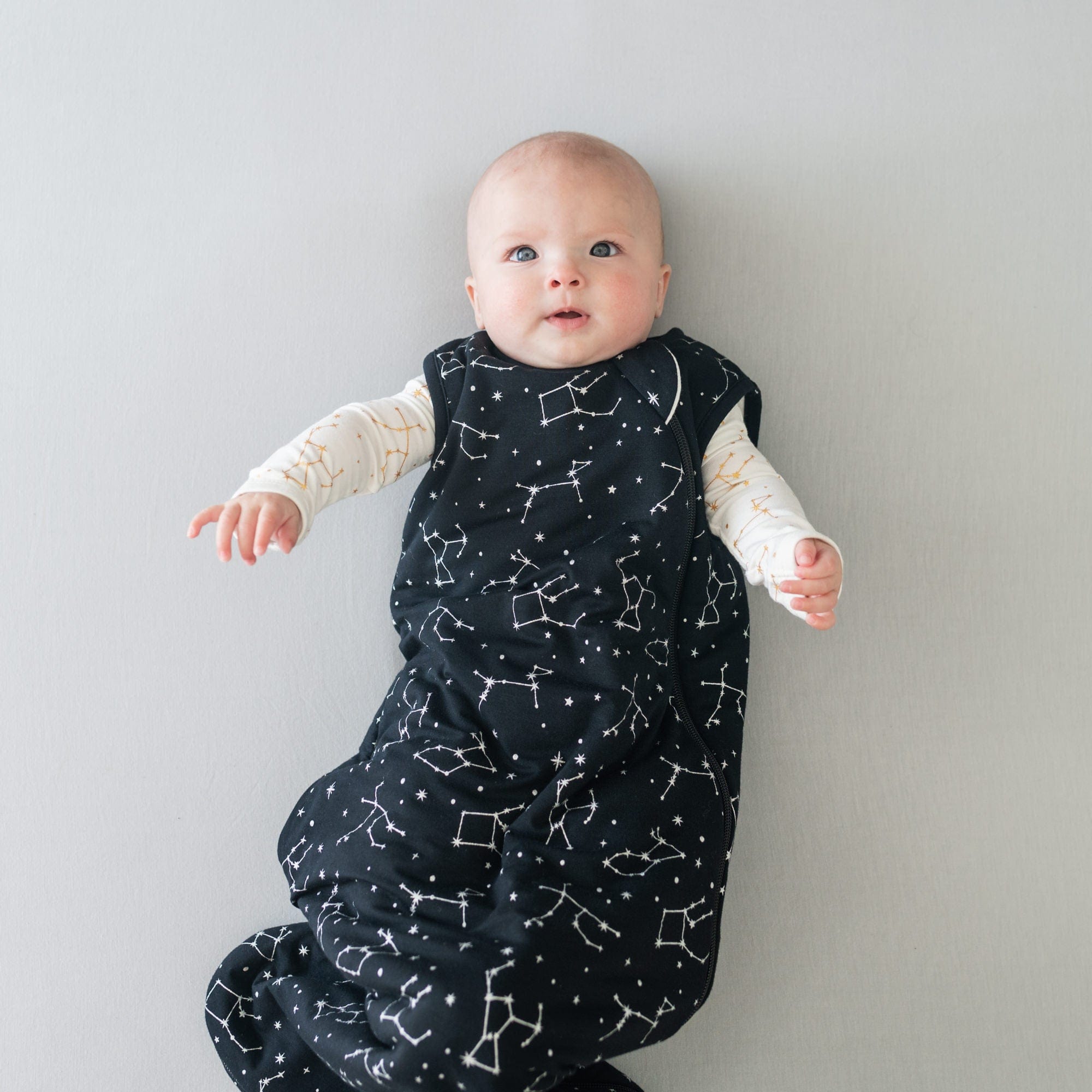 Infant wearing Kyte Baby Sleep Bag Midnight Constellations 1.0
