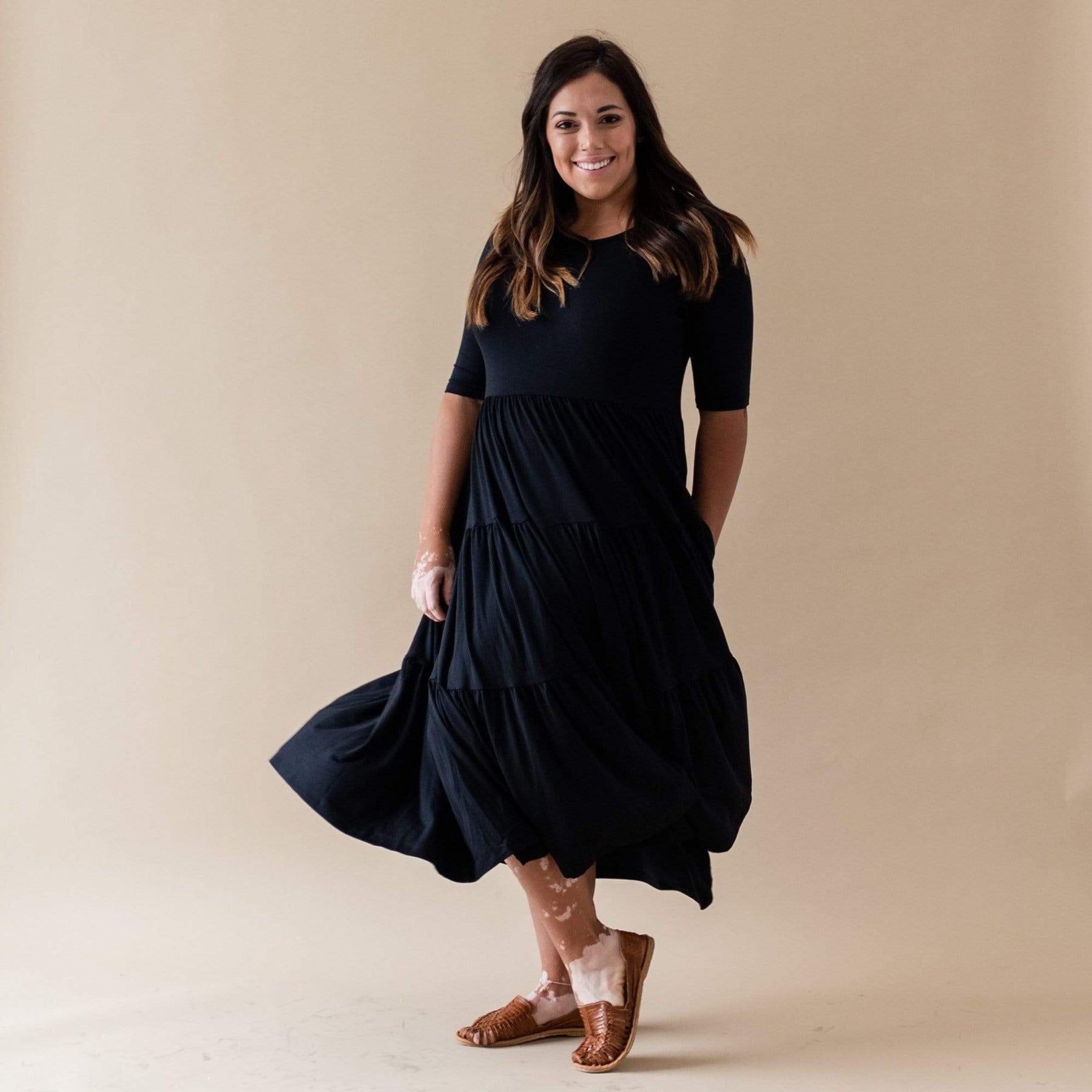 Woman wearing Kyte Baby bamboo scoop neck Tiered Dress in Midnight