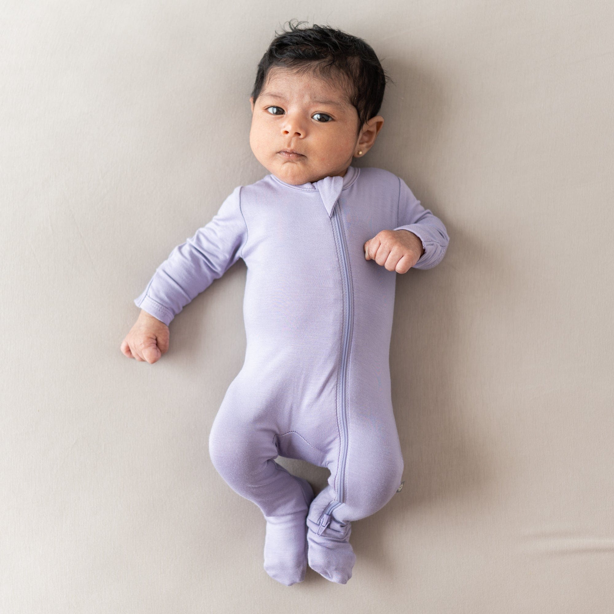 Infant wearing Kyte Baby Zippered Footie in Taro