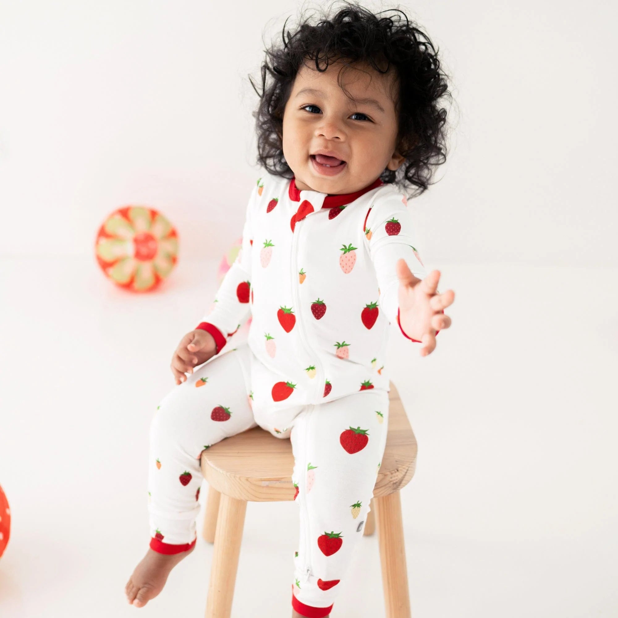 Toddler wearing Kyte Baby Zippered Romper in Strawberry